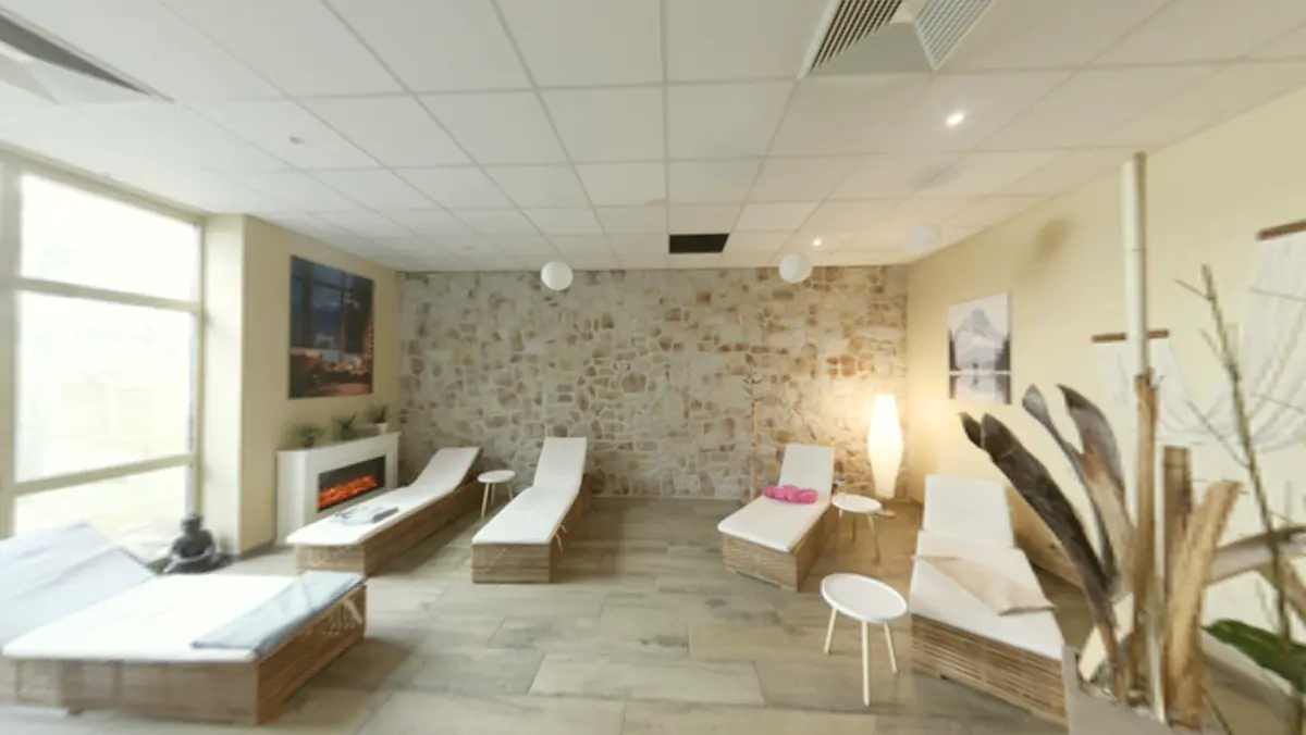 Entspannungslounge im POM Weimar mit Liegen, Kamin und Steinwand
